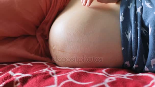 Zwangere vrouw raakt buik — Stockvideo