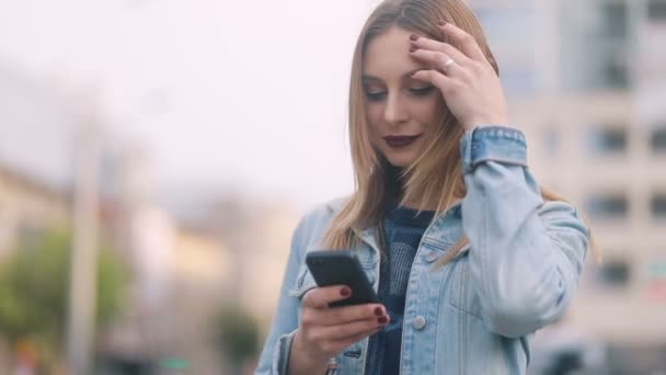 Žena SMS přes smartphone v parku — Stock video