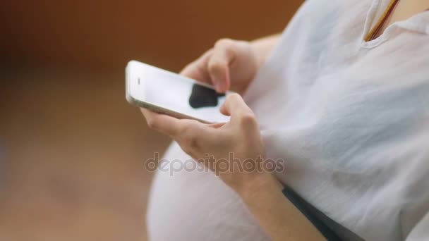 Mujer embarazada usando teléfono inteligente — Vídeos de Stock