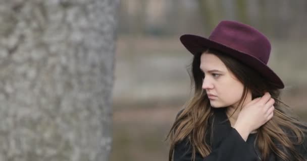 Молодая женщина, стоящая в парке — стоковое видео