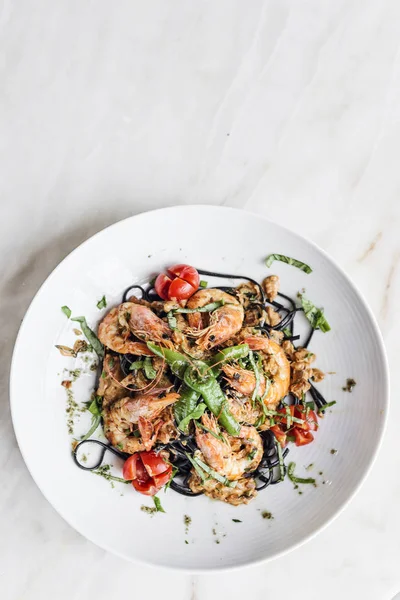 Gamberetti grigliati gourmet e verdure su pasta nera di calamaro — Foto Stock