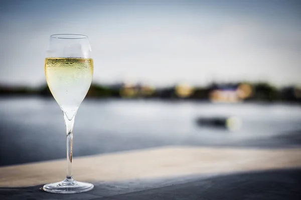 Sklenka šampaňského v moderní venkovní bar při západu slunce — Stock fotografie