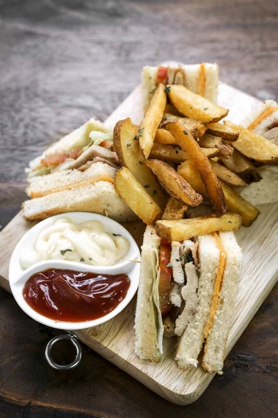 Classico club sandwich con patatine su tavola di legno — Foto Stock