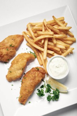 İngiliz geleneksel balık ve patates kızartması beyaz tabakta yenir.