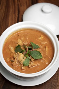 Tayland 'daki Phuket Thailand' daki ahşap masada hindistan cevizi sütü ile baharatlı panang domuz eti.