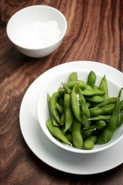 organik edamame fasulyesi çerezi ahşap masada deniz tuzu ile.