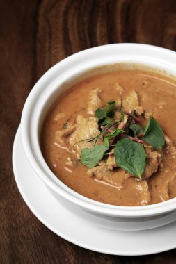 Tayland 'daki Phuket Thailand' daki ahşap masada hindistan cevizi sütü ile baharatlı panang domuz eti.