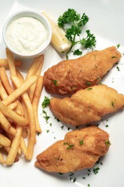 İngiliz geleneksel balık ve patates kızartması beyaz tabakta yenir.