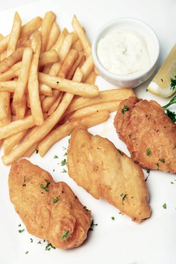 İngiliz geleneksel balık ve patates kızartması beyaz tabakta yenir.