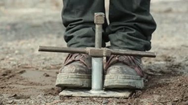 Bir işçi bir çıta yer altından çeker. 