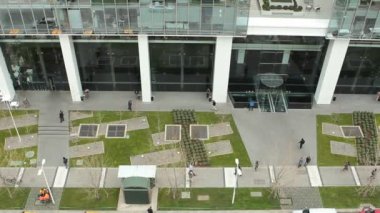 bir ofis binası önündeki kaldırımda yaya