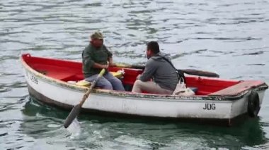 bir kürek teknede konuşan adam