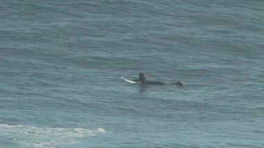 Sörf tahtası üzerinde kürek çekmeye adam