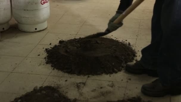 Un trabajador aplana pequeños montones de tierra — Vídeo de stock