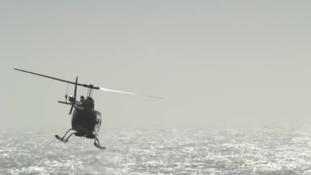 Helicóptero voando sobre a praia — Vídeo de Stock