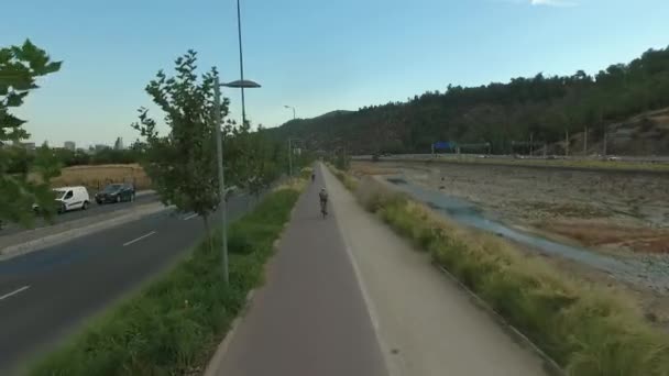 Ciclista cabalgando cerca de arroyo — Vídeos de Stock