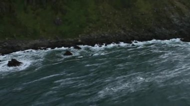 Okyanus dalgaları kayalık uçurumlarda gürültüyle çarpmak