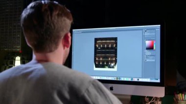 iMac önünde oturan adam