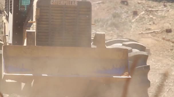 Бульдозер движется в пыли — стоковое видео