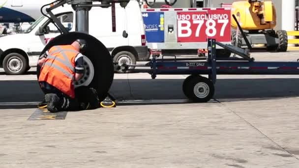 Trabalhador reparando a roda de um avião — Vídeo de Stock