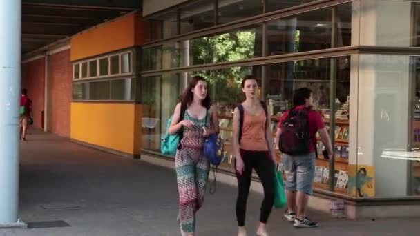 Estudantes que passam por uma livraria — Vídeo de Stock