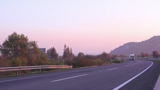 Puesta de sol en carretera con vehículos — Vídeos de Stock