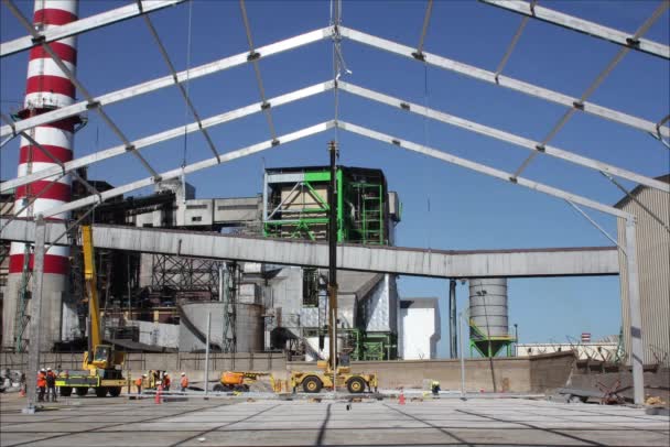 Camiones industriales y una grúa que construyen una estructura metálica — Vídeos de Stock