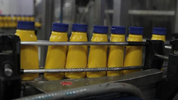 Garrafas de molho amarelo em uma linha de produção . — Vídeo de Stock