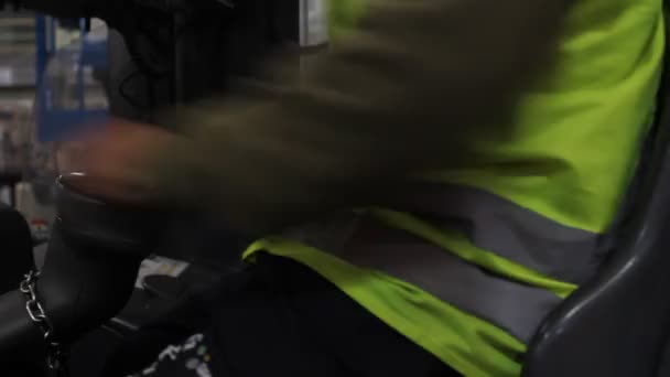 Работник поворачивает руль погрузчика — стоковое видео