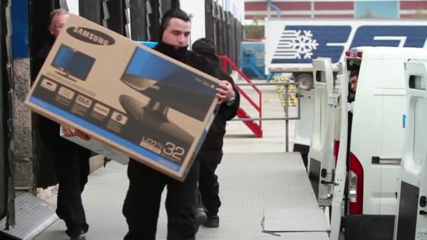 Рабочие грузят ящики в грузовик — стоковое видео