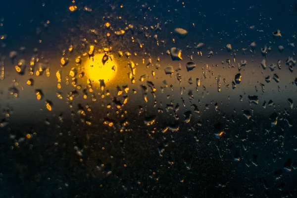 Sol desfocado e gotas de água na janela — Fotografia de Stock