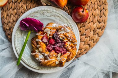 Vintage plaka üzerinde bir gül ile kahvaltıda Frambuaz reçeli ile taze lezzetli çörekler