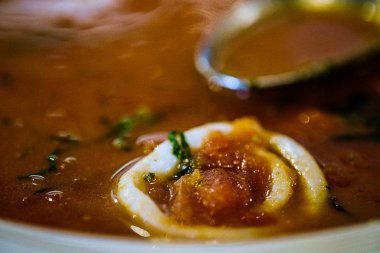 Lezzetli sıcak domates çorbası bir kaşık ile yakın çekim.