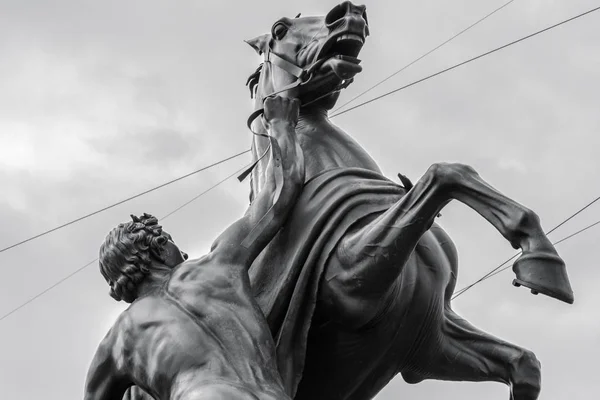 Scultura dell'uomo che tiene un cavallo pazzo. Bianco e nero — Foto Stock