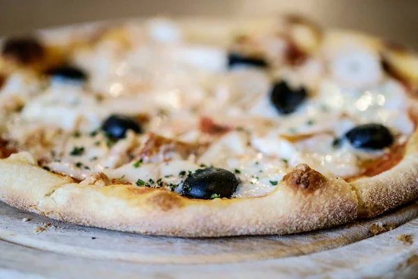 Leckere Pizza mit frischen Oliven und knusprigem Rand aus nächster Nähe. lizenzfreie Stockbilder