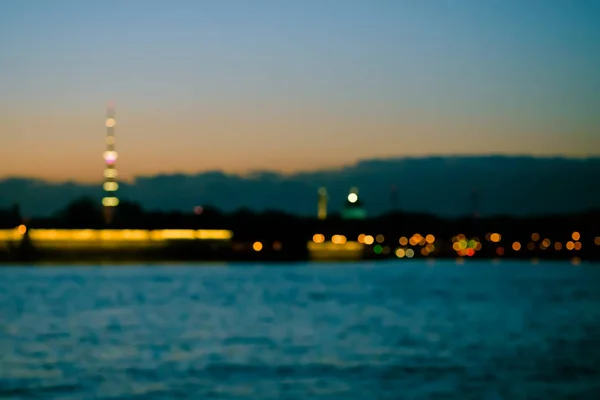 Abstrakte verschwommene Lichter über dem Hintergrund des Stadtflusses. schöner sonnenuntergang über dem neva fluss von st. petersburg, russland — Stockfoto