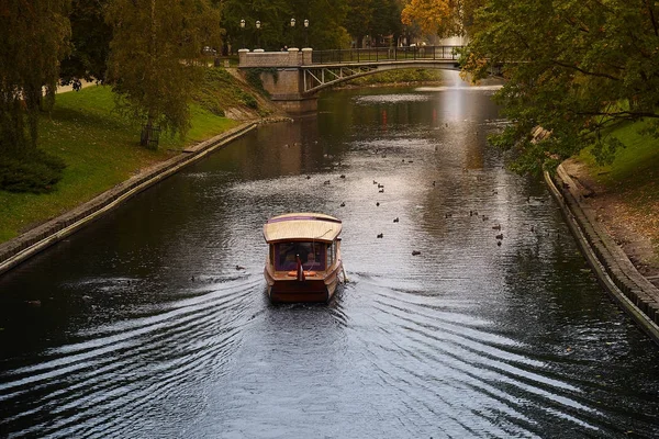 Een boot zeilen in het park in de buurt van de Letse nationale opera en ballet theater in Riga, Letland. — Stockfoto