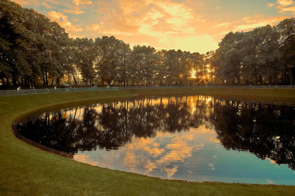 Prachtige zonsondergang op Karpeev meer van de vijver in de tuin van de zomer in Sint-Petersburg, Rusland. — Stockfoto