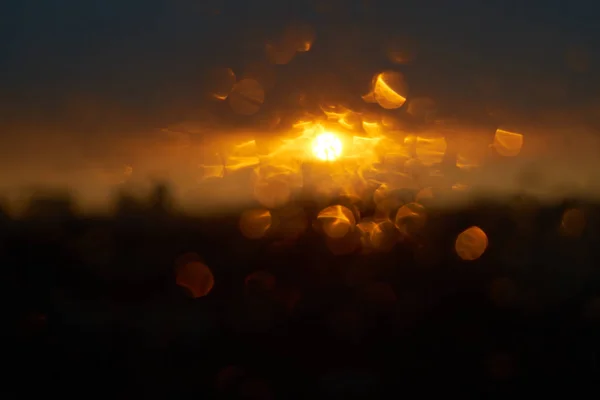 Chuva cai textura no vidro da janela com lindo colorido laranja âmbar pôr do sol luz abstrato embaçado cityscape horizonte bokeh fundo. Foco suave . — Fotografia de Stock