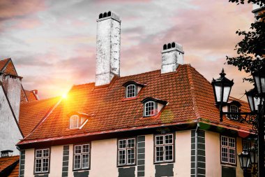 Çatılar eski evler Skarnu iela Riga, Letonya sokak harika objektif fişekleri ile mavi gökyüzü karşı içinde