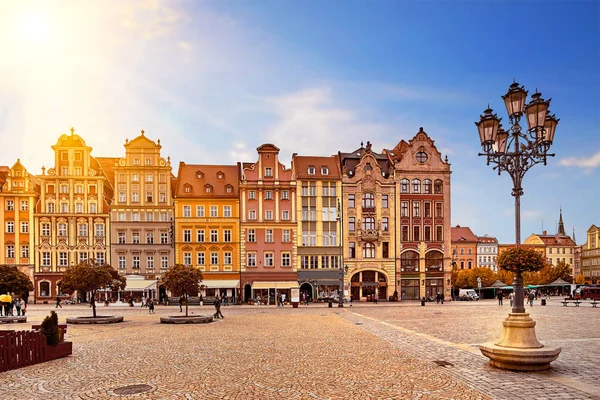 Merkezi Pazar Meydanı Wroclaw Polonya eski renkli evleri, sokak fener lambası ve yürüyen turist insanlara muhteşem çarpıcı sabah gündoğumu güneş ışığı ile. Seyahat tatil kavramı