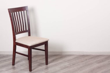 Beyaz bir duvara yastık ile ahşap sandalye