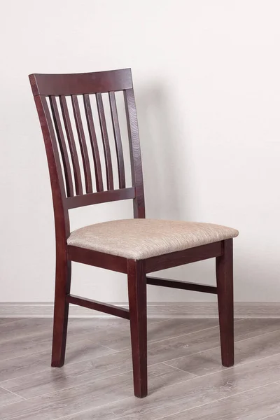 Dřevěná židle s čalouněním proti bílé zdi — Stock fotografie