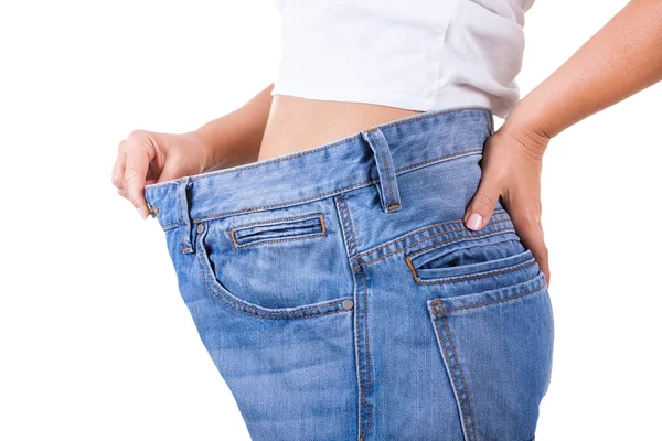 Concetto di dieta. Donne magre in grandi jeans che mostrano il peso di successo — Foto Stock