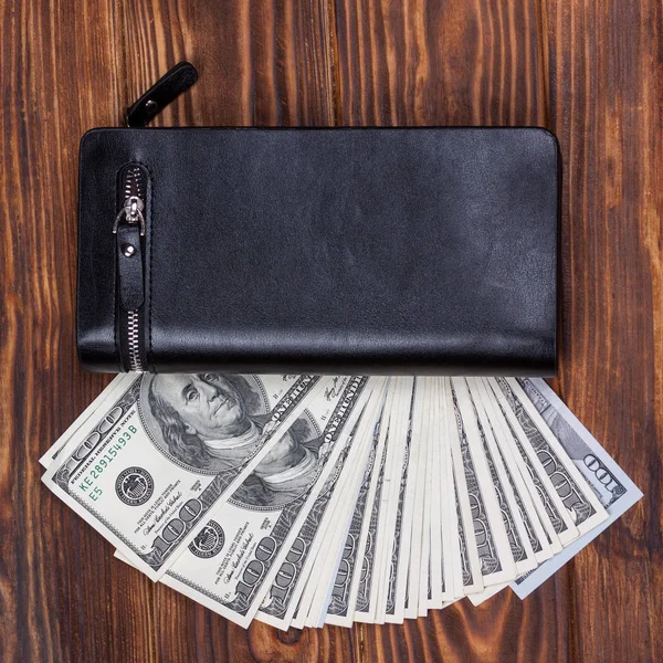 Hundert-Dollar-Banknoten in schwarzer Ledertasche — Stockfoto