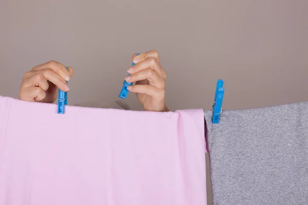 Manos de mujer colgando paño limpio húmedo para secar en la línea de ropa en La — Foto de Stock