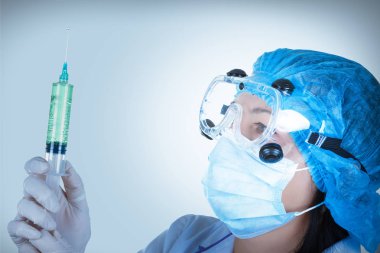 Genç kadın doktor şırıngada elinde mavi tuş ile