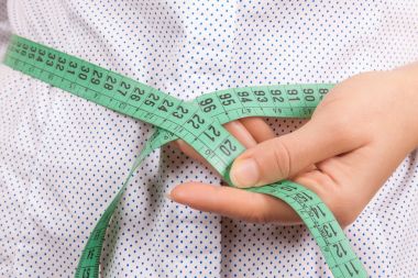 Kilo kaybı ve sağlıklı yaşam konsepti. Fitness kadın Measuri
