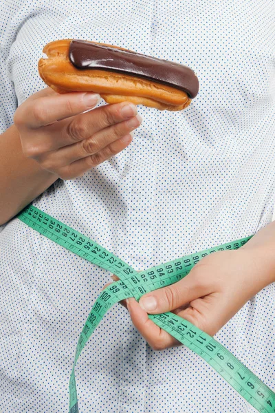 Concepto de dieta. Mujer joven con chocolate Eclair midiendo su Wa — Foto de Stock