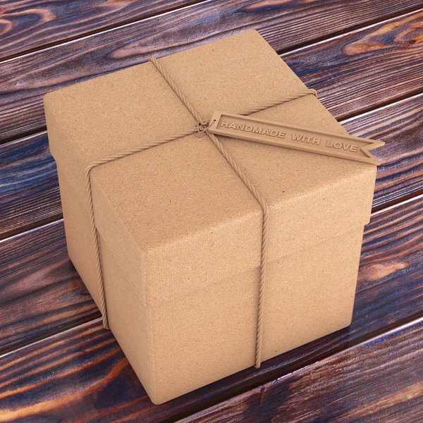 Подарочная коробка из картона с веревкой и деревянной этикеткой ручной работы — стоковое фото